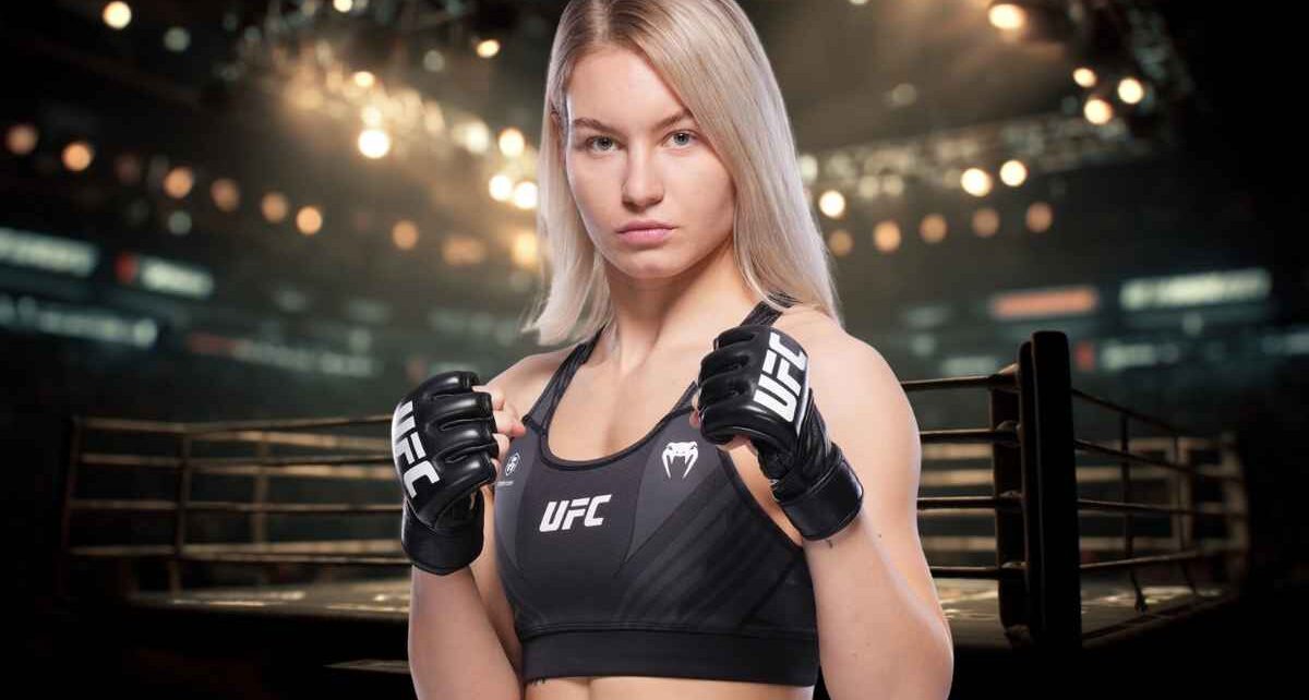 Female UFC fighter wearing gloves and sports top inside an arena