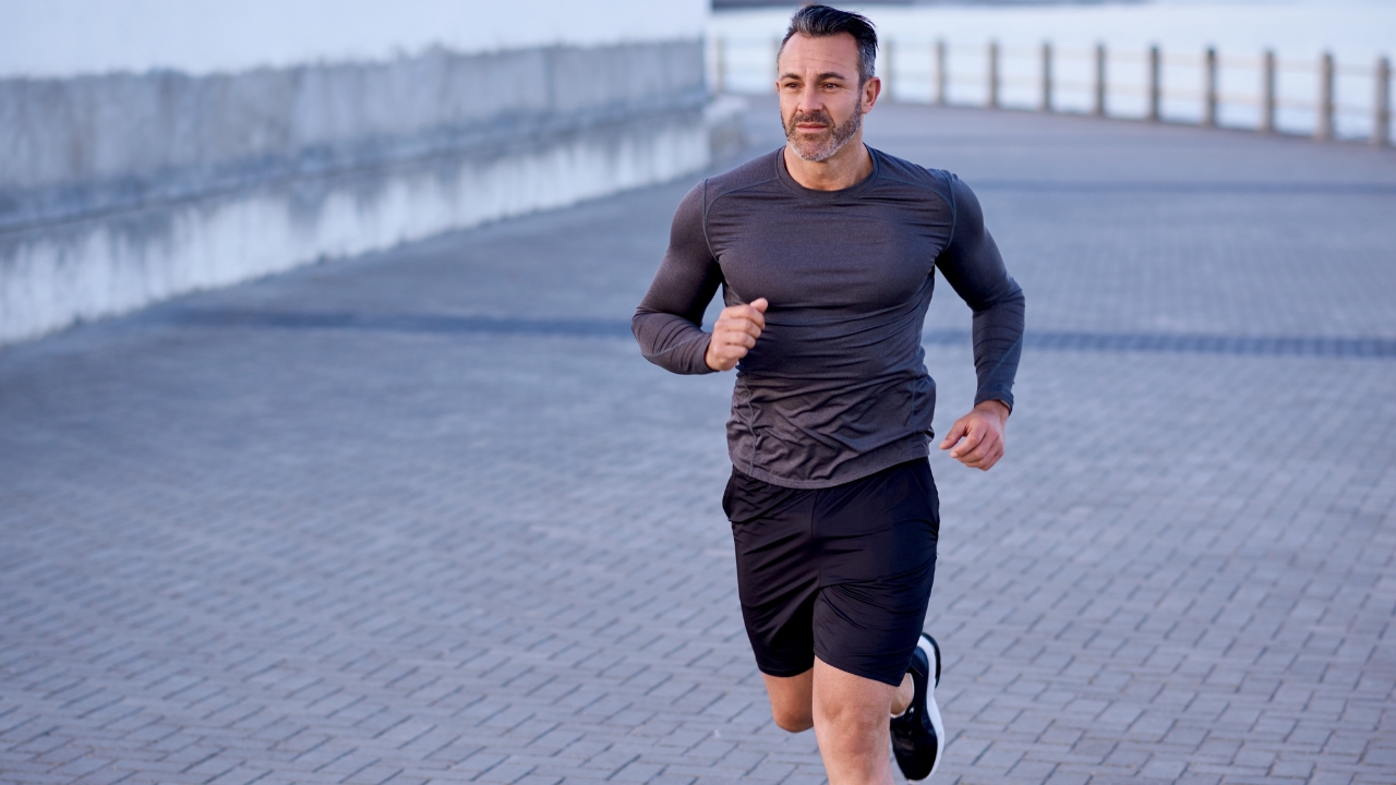 Man runs outdoors showing forward movement in the sagittal plane