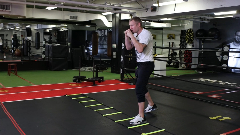Boxer moves through an agility ladder to build speed and coordination during footwork drills