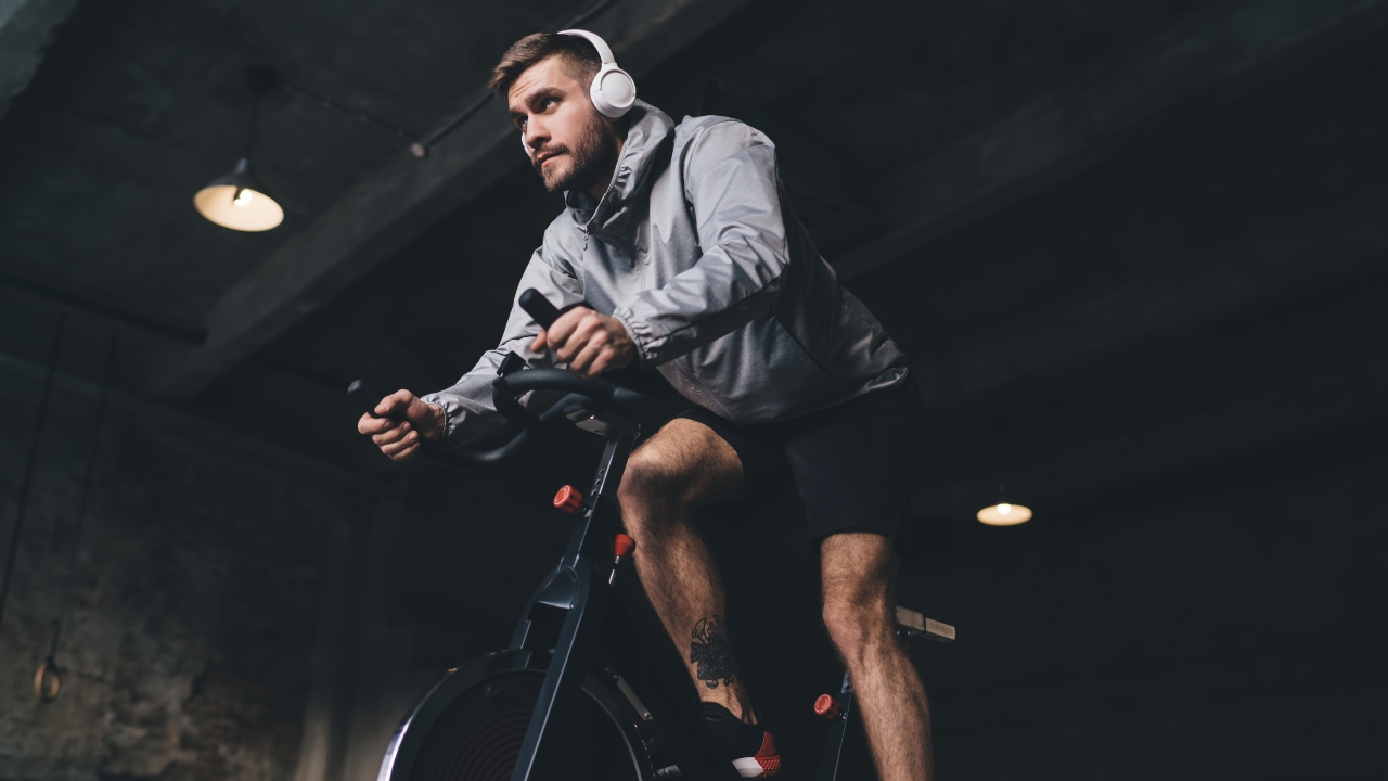 Man rides a stationary bike during a cardio workout in a gym